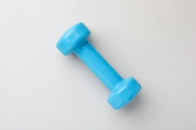Photo of Blue vinyl dumbbell on light background, top view