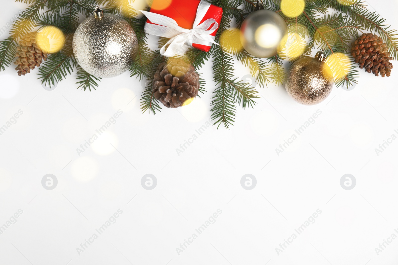 Photo of Christmas greeting card with space for text. Flat lay composition of fir tree branches and festive decor on white background