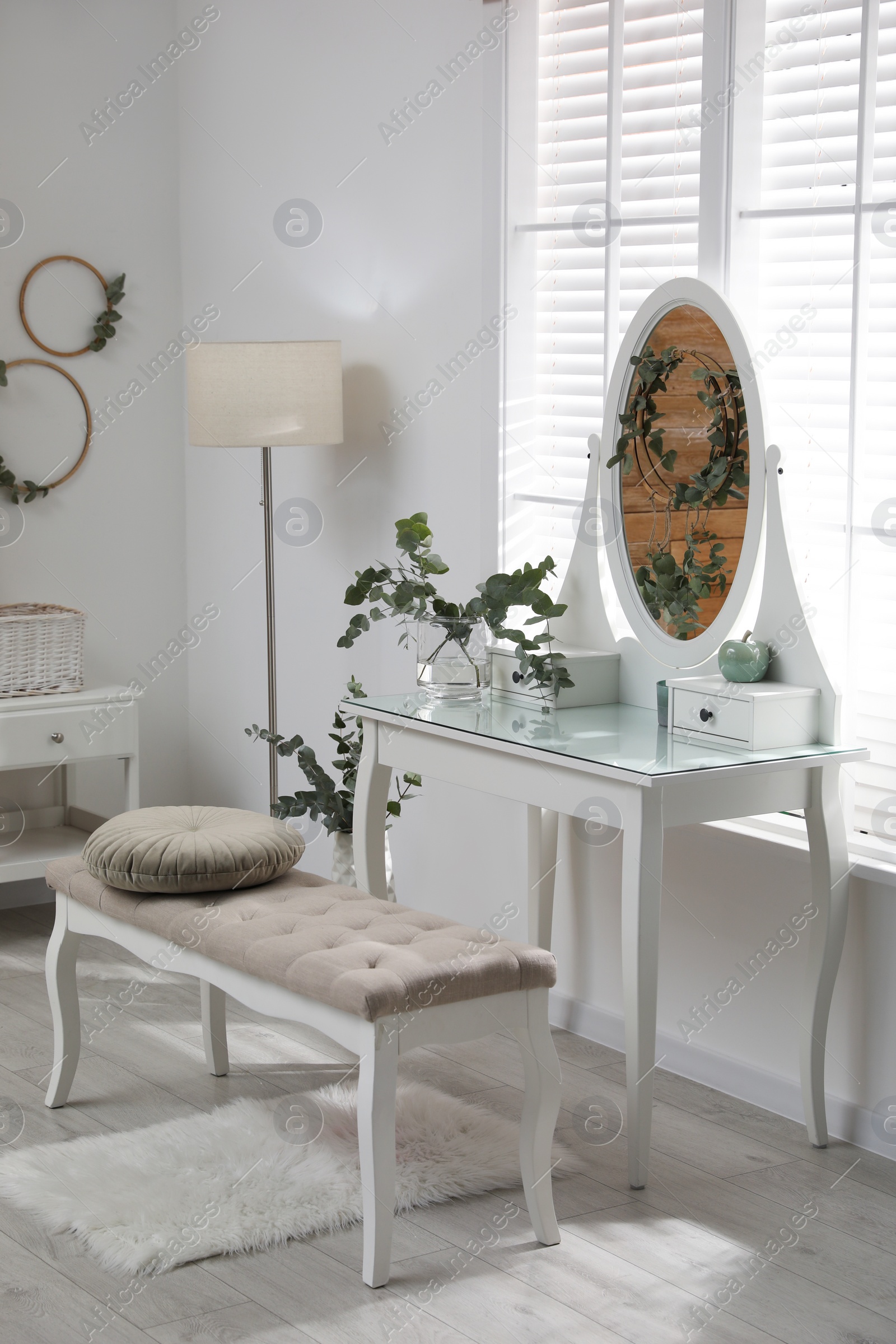 Photo of Stylish dressing table decorated with beautiful eucalyptus branches indoors