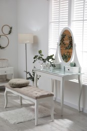 Stylish dressing table decorated with beautiful eucalyptus branches indoors