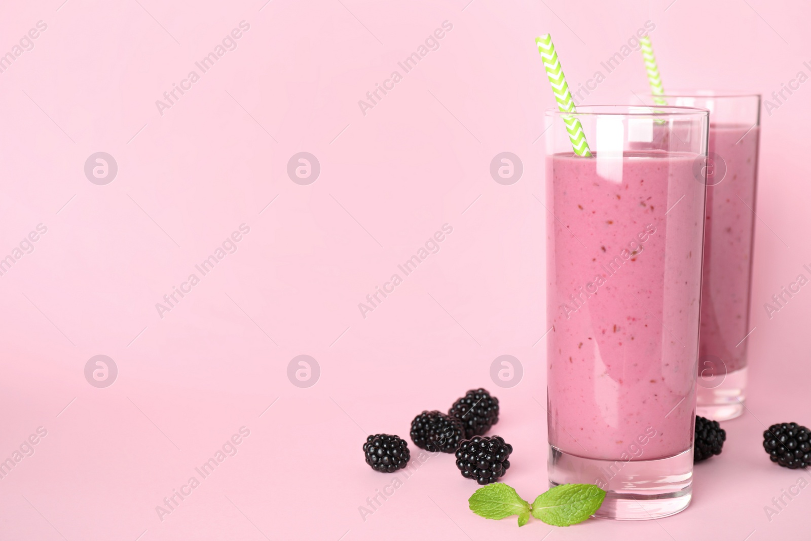 Photo of Delicious blackberry smoothie on pink background. Space for text