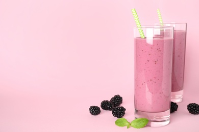 Delicious blackberry smoothie on pink background. Space for text