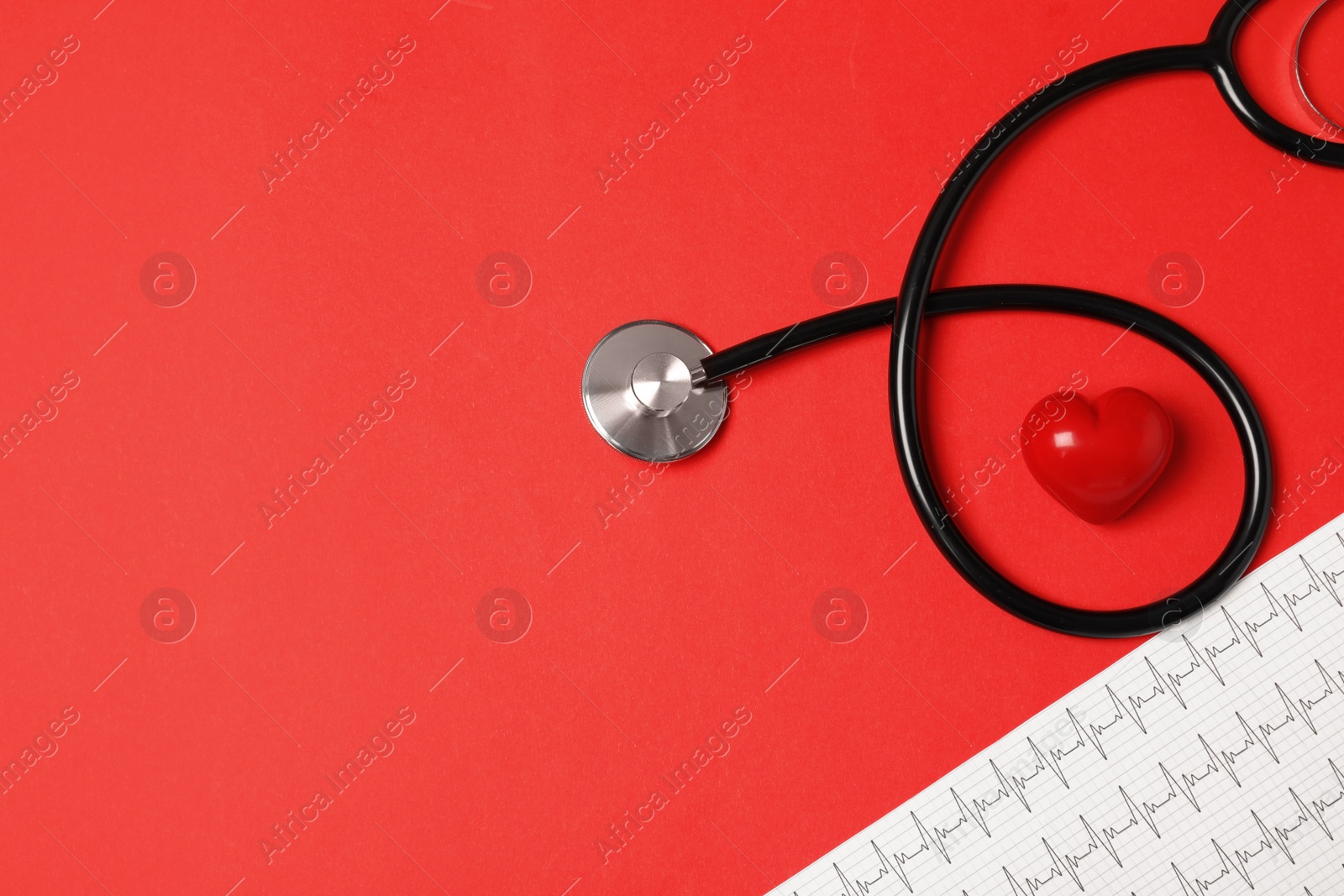 Photo of Flat lay composition with stethoscope, heart figure and cardiogram on color background. Space for text