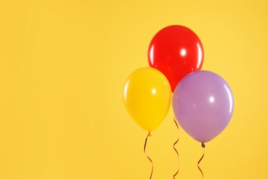 Bright balloons on color background, space for text. Celebration time