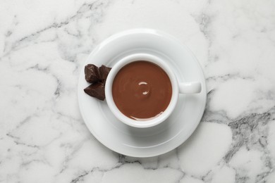 Photo of Yummy hot chocolate in cup on white marble table, top view