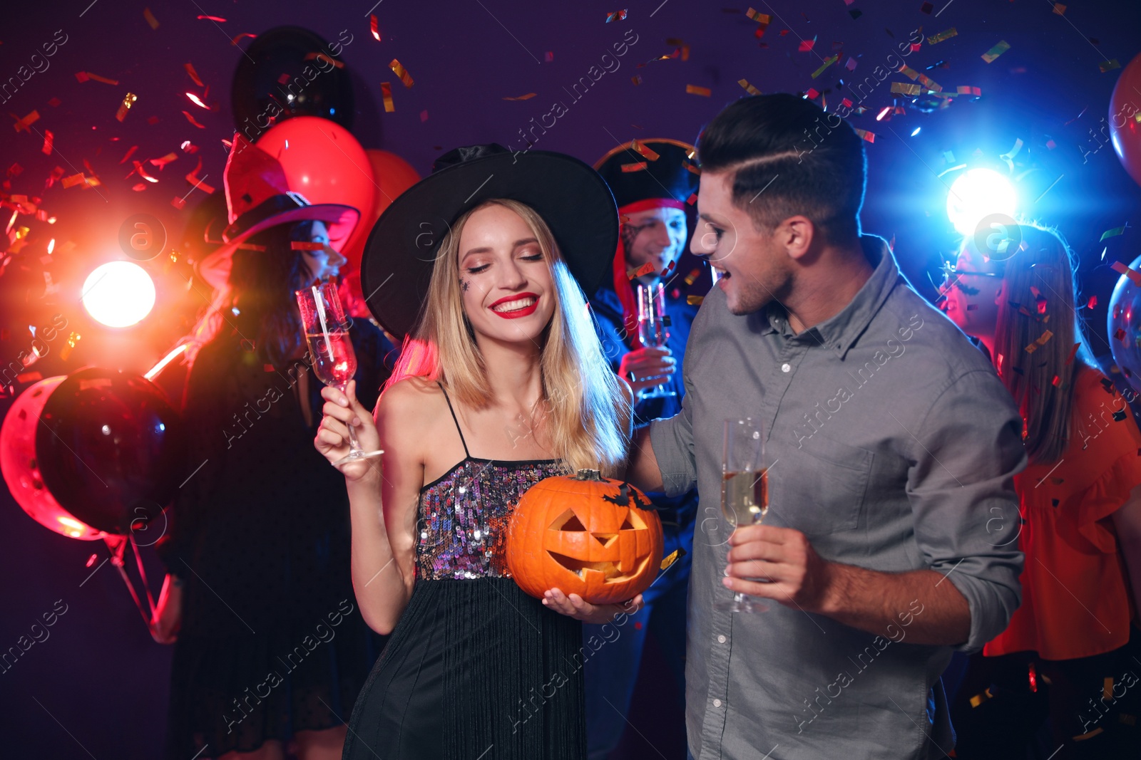 Photo of Happy couple enjoying Halloween party on dark background