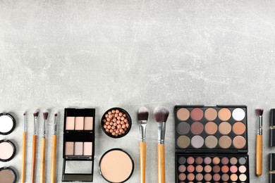 Photo of Flat lay composition with makeup brushes on grey stone table, space for text