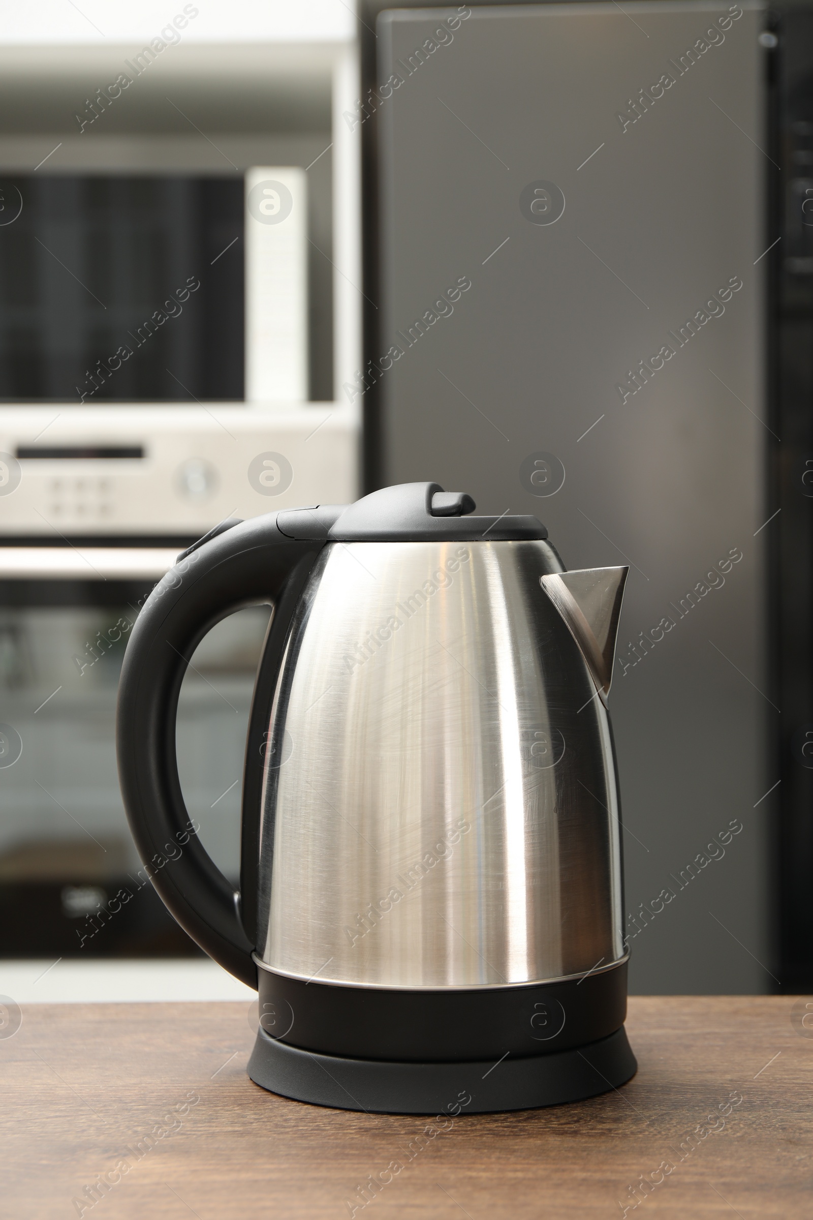 Photo of Modern electric kettle on table in kitchen