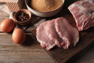 Photo of Different ingredients for cooking schnitzel on wooden table