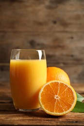 Photo of Glass of orange juice and fresh fruits on wooden table