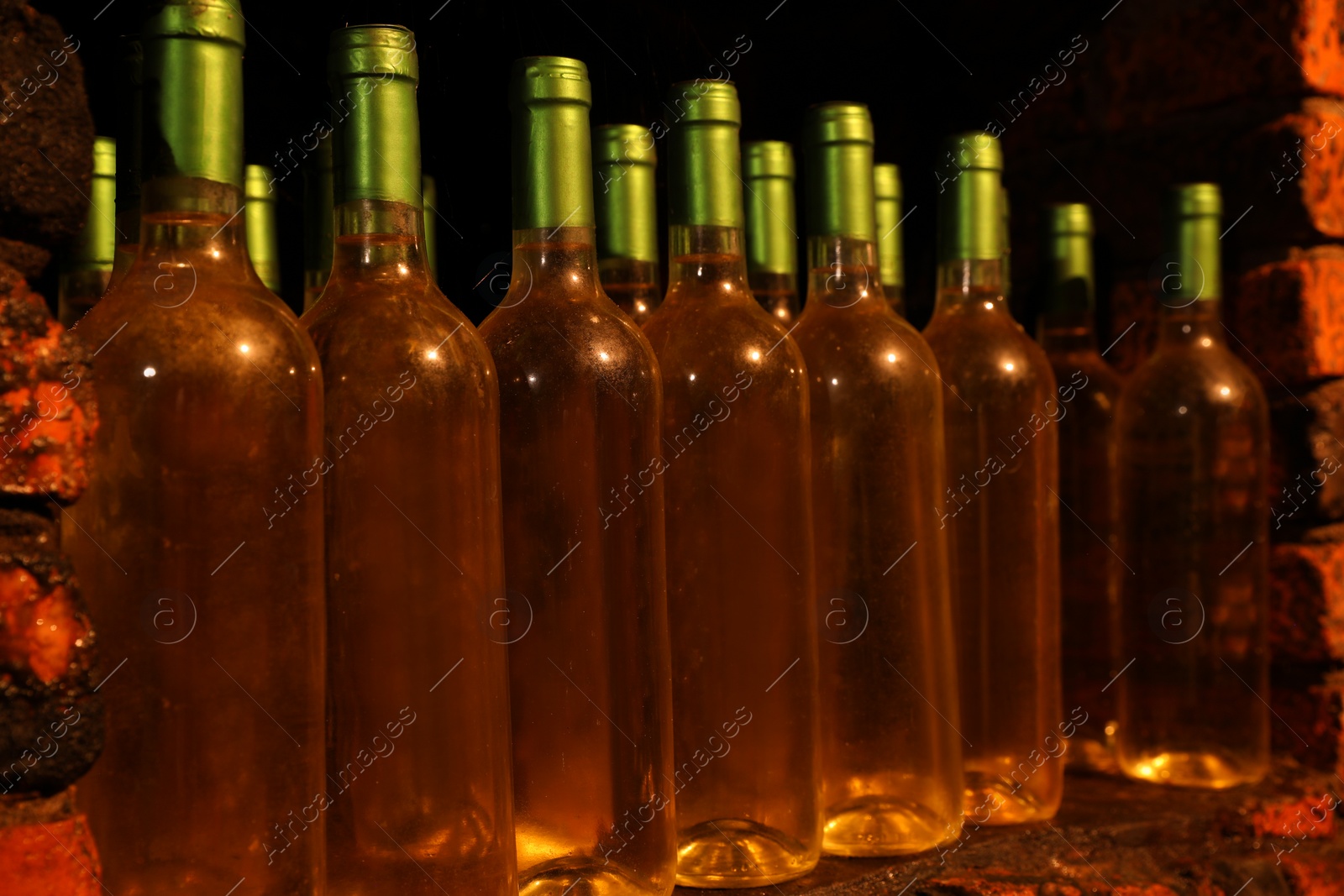 Photo of Many bottles of alcohol drinks on shelf in cellar