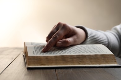 Photo of Woman with Bible at wooden table, closeup
