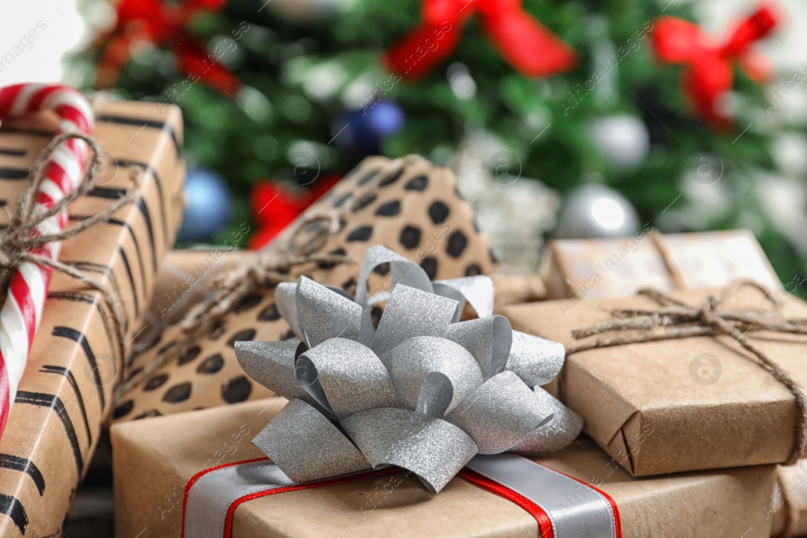 Photo of Beautiful gift boxes and blurred Christmas tree on background