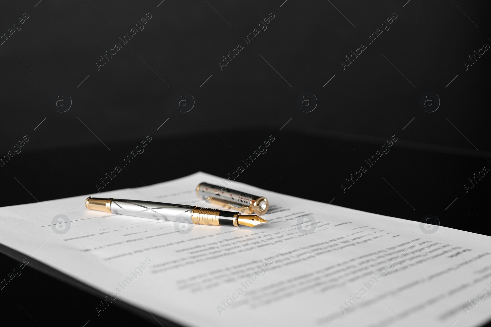 Photo of Fountain pen and document on black table. Notary services