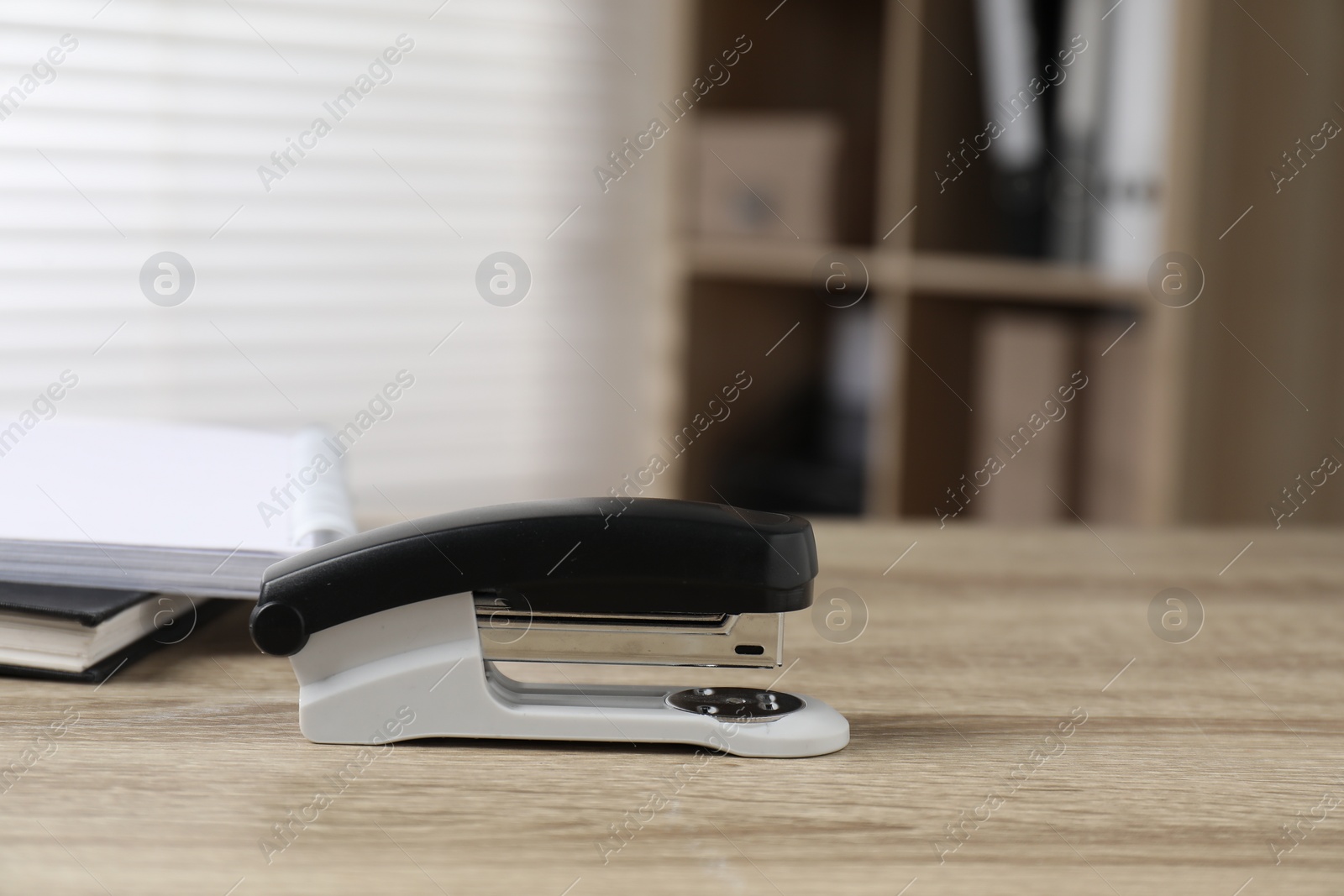 Photo of One stapler on wooden table indoors, closeup. Space for text