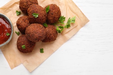 Vegan meat products. Delicious falafel balls, parsley and sauce on white table, flat lay. Space for text