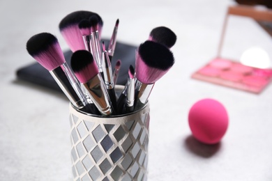 Photo of Holder with professional makeup brushes, closeup