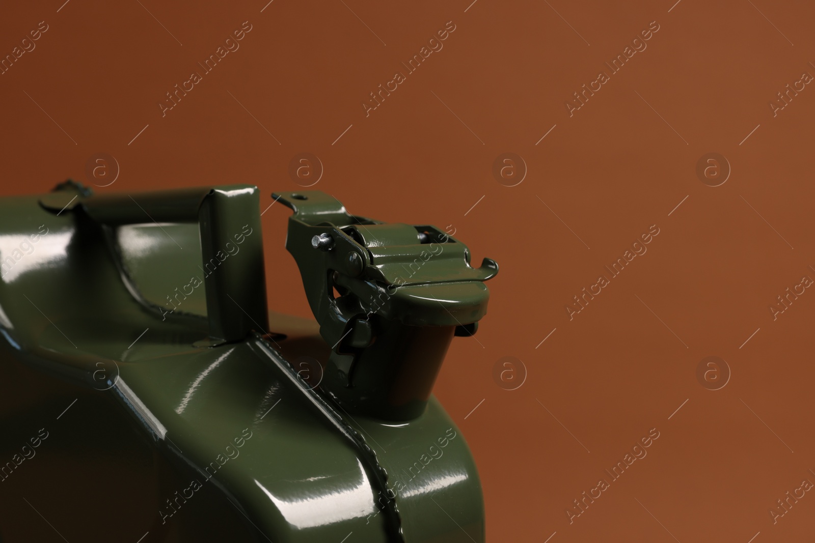 Photo of New khaki metal canister on brown background, closeup. Space for text