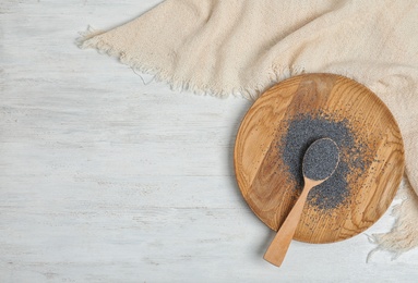 Flat lay composition with poppy seeds and space for text on white wooden background