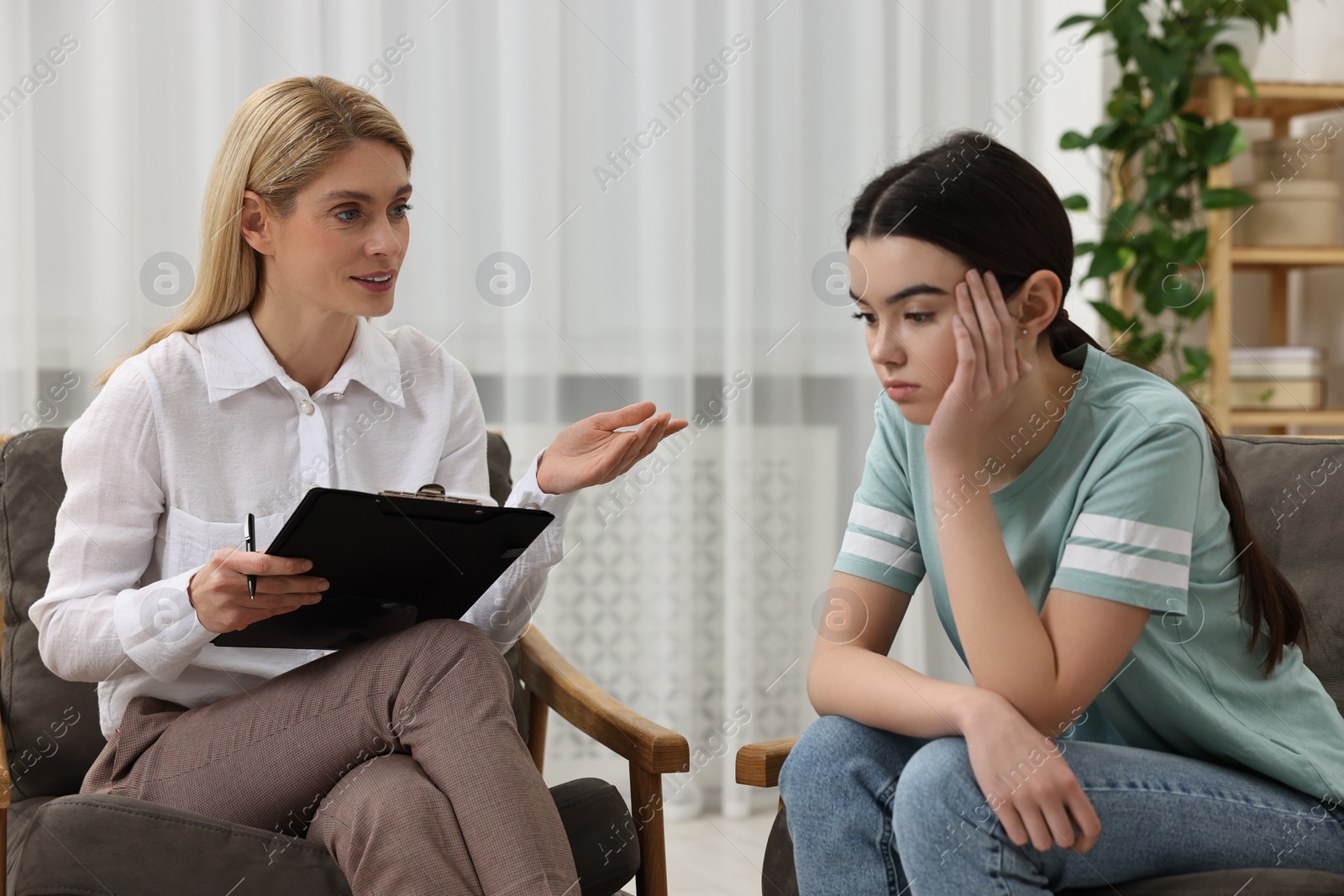 Photo of Psychologist working with teenage girl in office