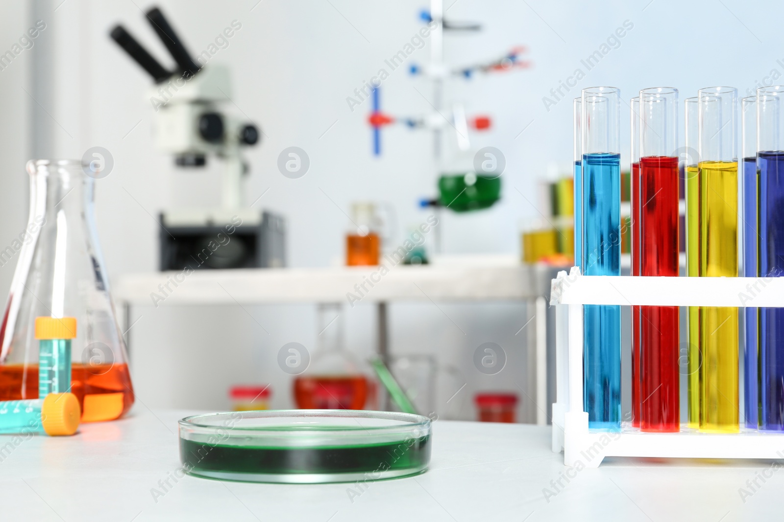 Photo of Different glassware with samples on table in chemistry laboratory