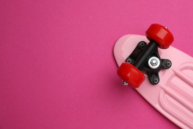 Skateboard on crimson background, top view. Space for text