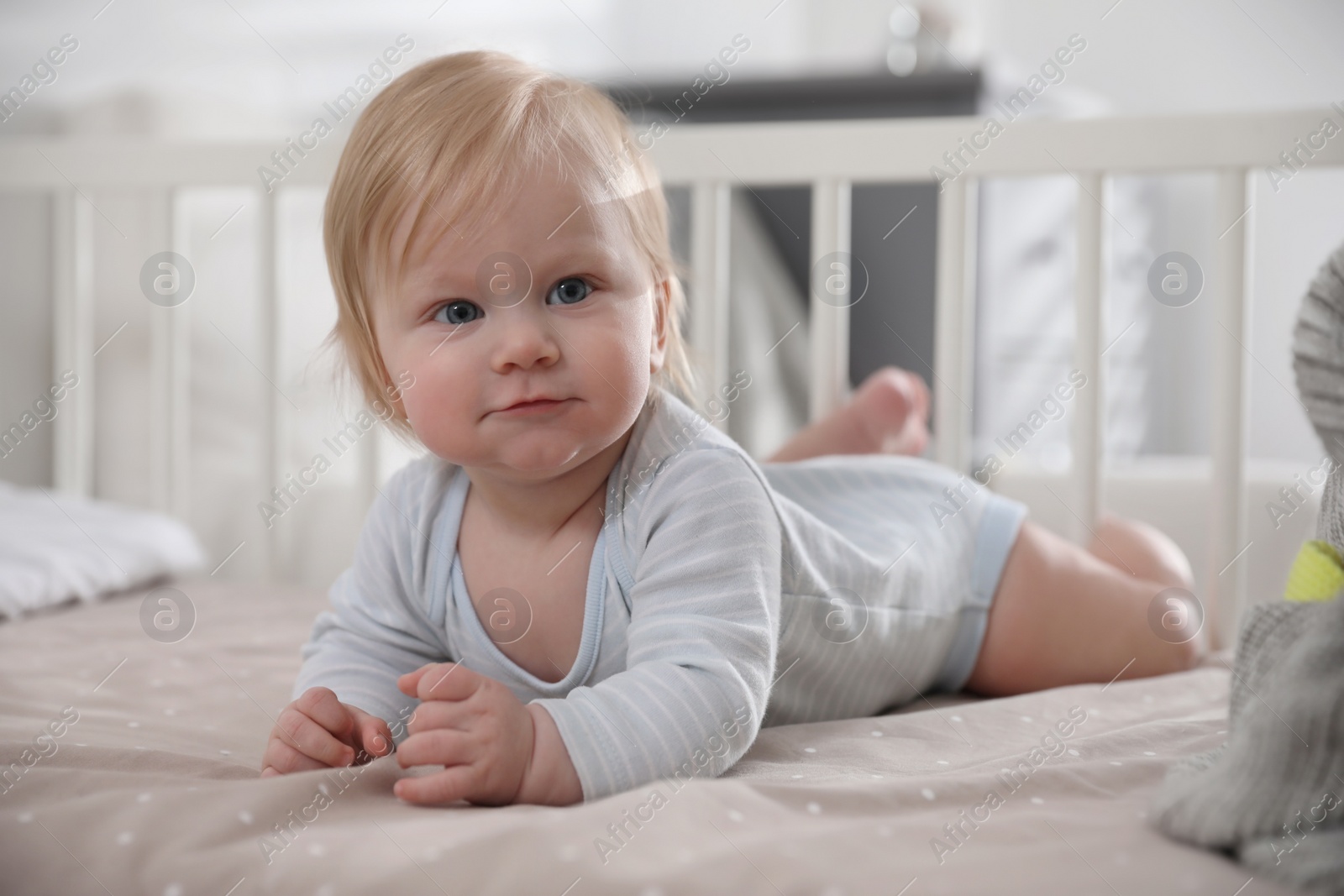 Photo of Adorable little baby lying in comfortable crib