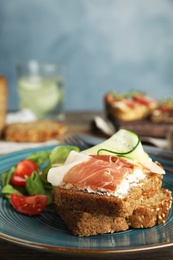 Plate of delicious bruschettas with prosciutto on table