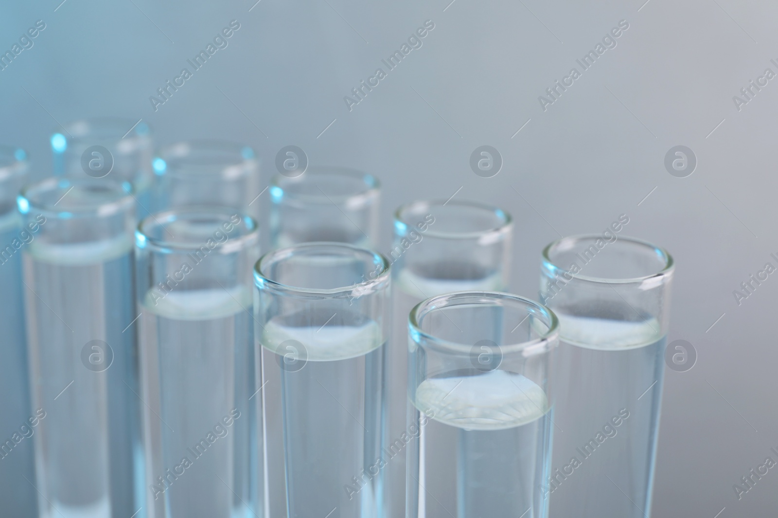 Photo of Laboratory analysis. Test tubes with liquid samples on color background, closeup