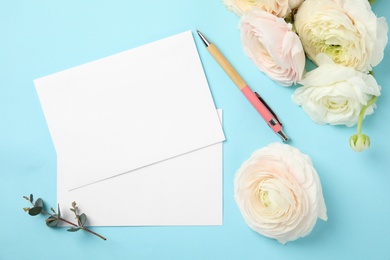 Photo of Flat lay composition with spring ranunculus flowers and cards on color background. Space for text