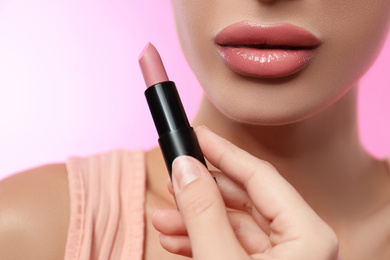 Photo of Woman with glossy lipstick on pink background, closeup