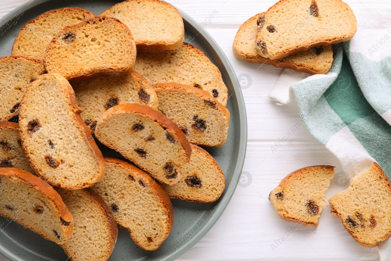 Photo of Sweet hard chuck crackers with raisins on white wooden table, flat lay