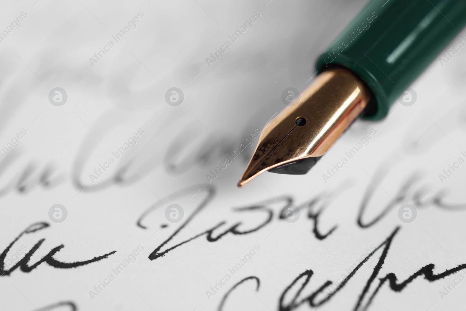 Photo of Elegant fountain pen on handwritten letter, closeup