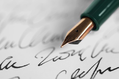 Photo of Elegant fountain pen on handwritten letter, closeup