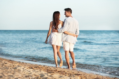 Photo of Happy young couple walking together on beach