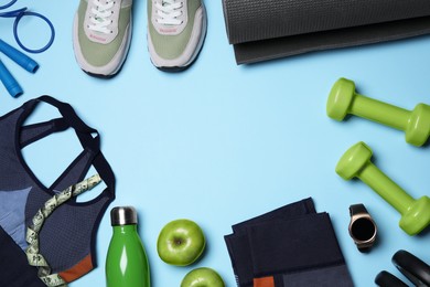 Photo of Sports equipment, apples and clothes on light blue background, flat lay with space for text. Personal training