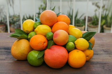 Photo of Different fresh citrus fruits on wooden table