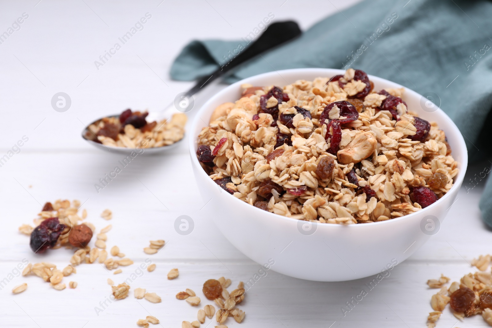 Photo of Bowl of tasty granola on white wooden table