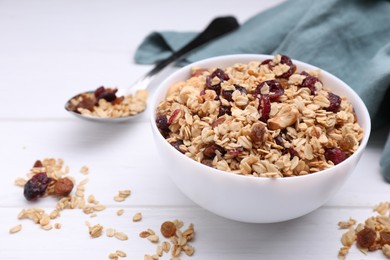 Photo of Bowl of tasty granola on white wooden table