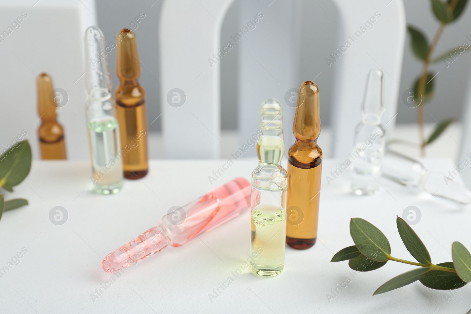 Photo of Stylish presentation of different skincare ampoules on white background, closeup