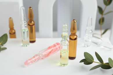 Stylish presentation of different skincare ampoules on white background, closeup