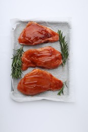 Photo of Raw marinated meat and rosemary on white background, top view