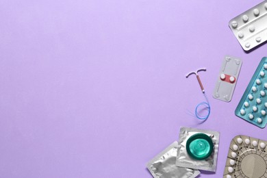 Photo of Contraceptive pills, condoms and intrauterine device on color background, flat lay with space for text. Different birth control methods