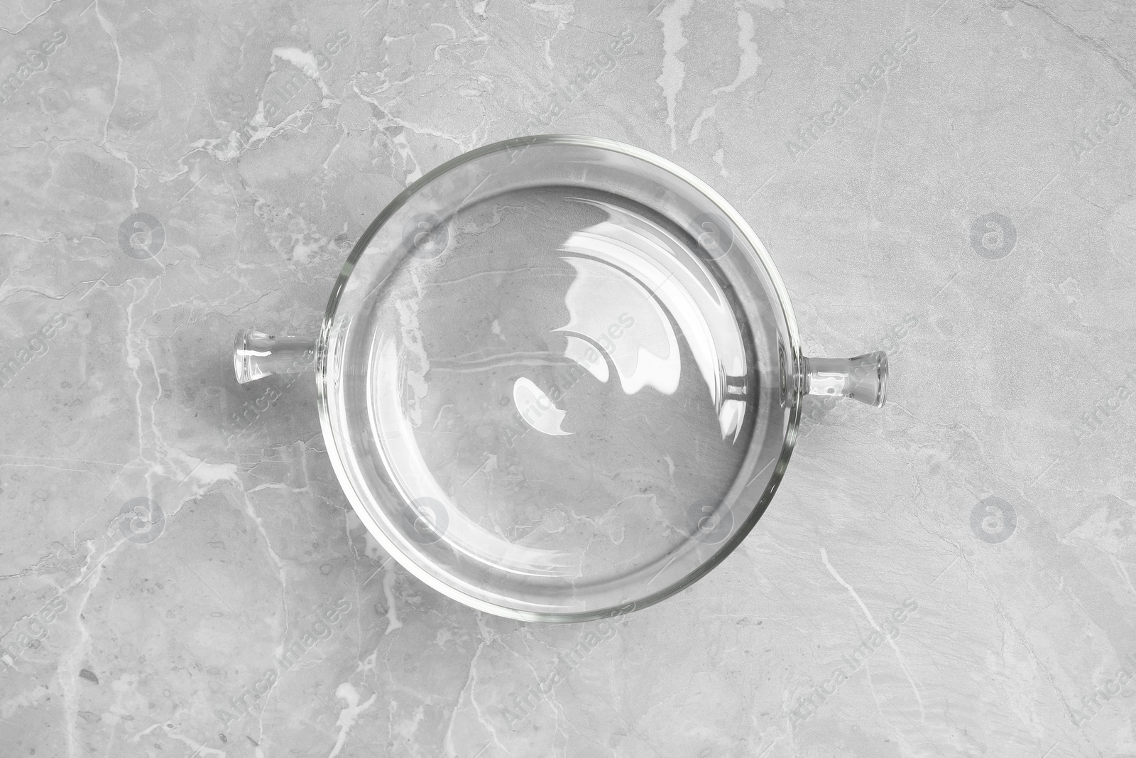 Photo of Glass pot with lid on light grey marble table, top view