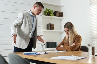 Photo of Businessman scolding employee for being late in office