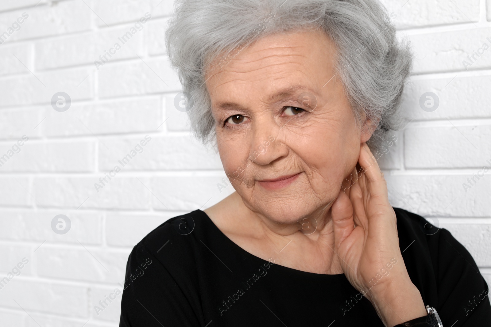 Photo of Portrait of mature woman near brick wall