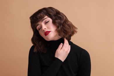 Portrait of beautiful young woman with wavy hairstyle on beige background