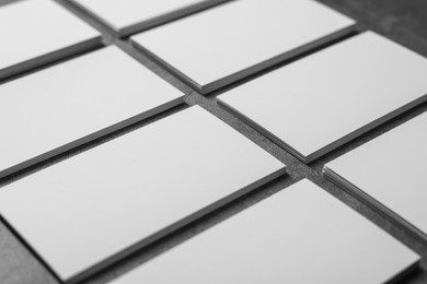 Blank business cards on grey textured table, closeup. Mockup for design