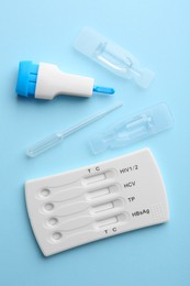 Photo of Disposable multi-infection express test kit on light blue background, flat lay