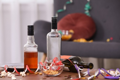 Photo of Messy table with bottles after party indoors, closeup